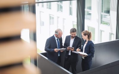 Group of businesspeople having a discussion near staircase in office